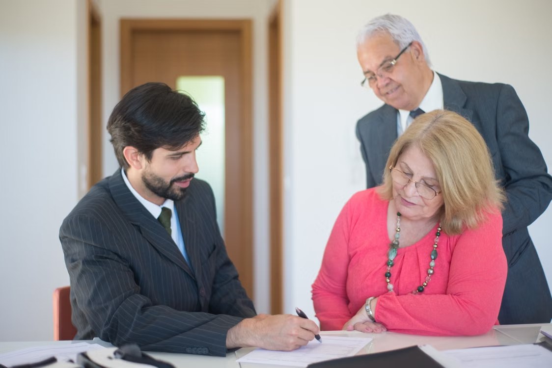 A senior couple reviewing property documents with a professional